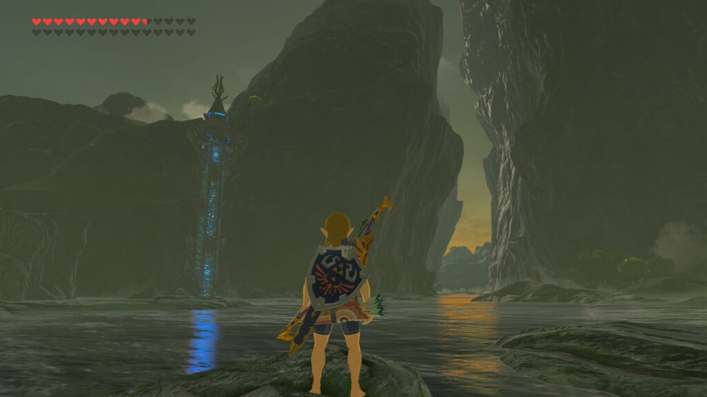 Link explorant une zone rocheuse avec une tour Sheikah dans The Legend of Zelda Breath of the Wild sur Nintendo Switch
