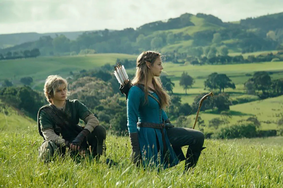 Link et Zelda se reposant dans l'herbe avec les montage en fond dans une image du film live-action The Legend of Zelda